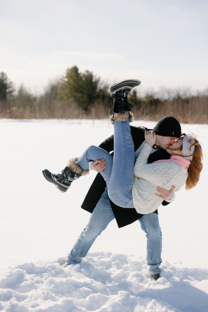 Couple dancing and kissing in the snow in a field