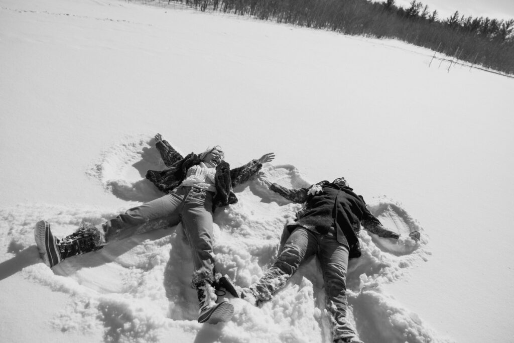 Couple making snow angels in the snow