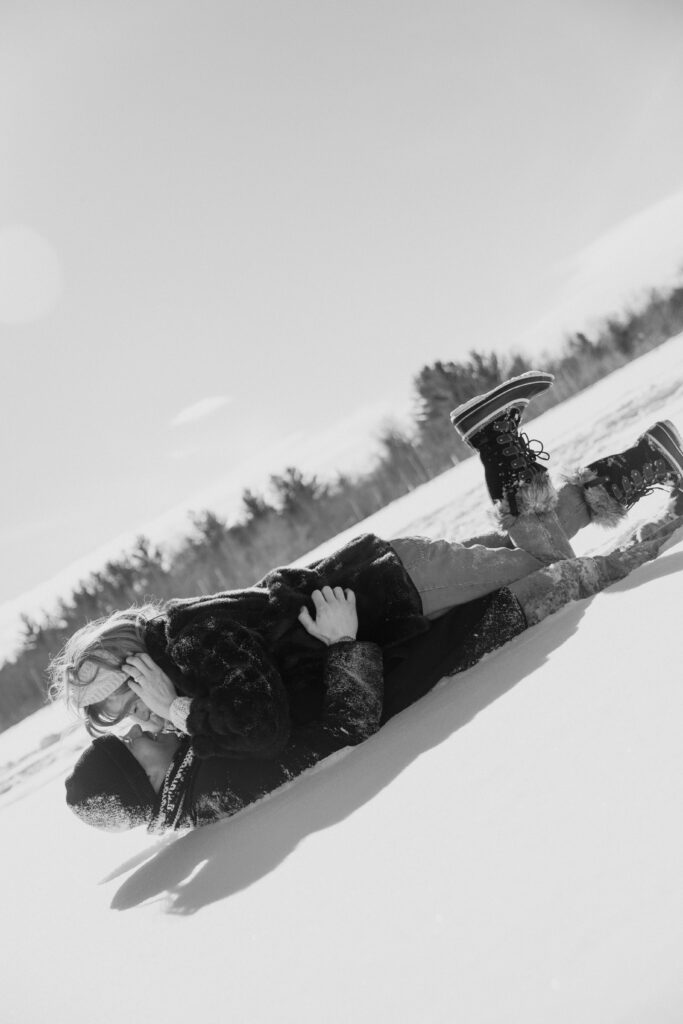 Couple laying in the snow kissing