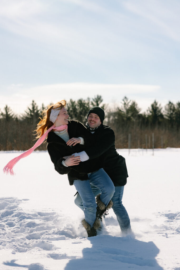 Couple playing the snow in a field