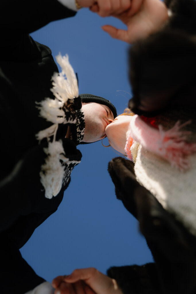Couple kissing shot from below with the sky above