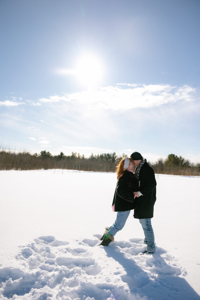 Couple snuggling and kissing in the snow