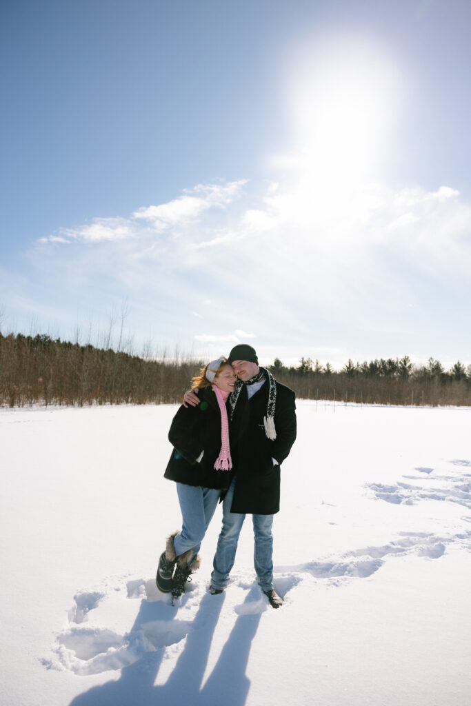 Couple snuggling and standing in the snow