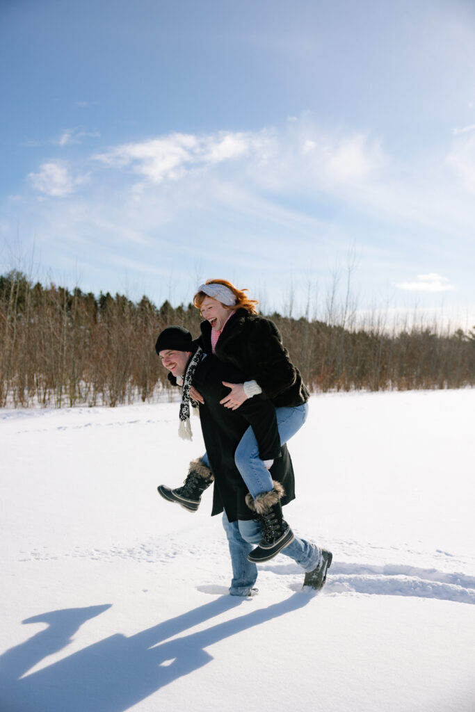 Couple giving piggyback in a field of snow