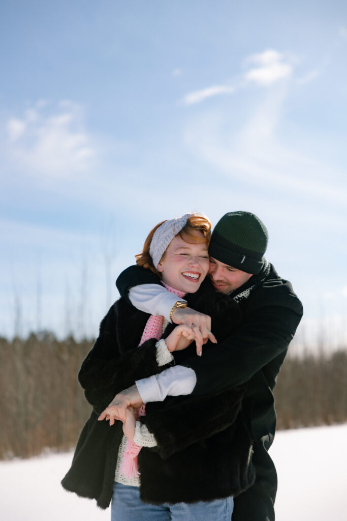 Couple playing the snow in a field