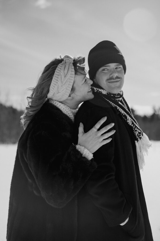 Couple snuggling and kissing in the snow