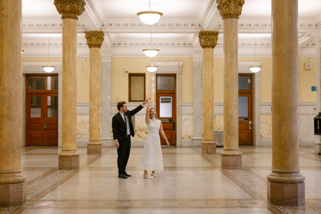 Toronto Old City Hall Civil Ceremony Couple twirling in hallway