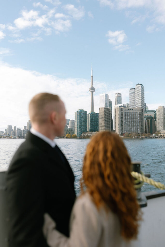Toronto Island proposal couple looking at skyline on boat