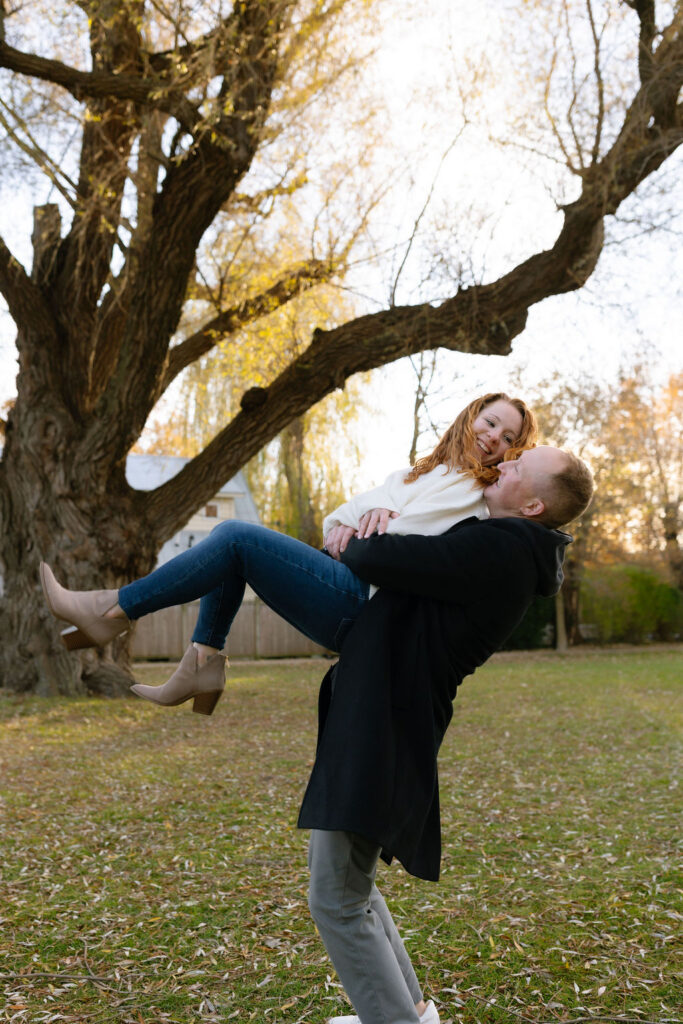 Toronto Island proposal couple lifting up woman and laughing