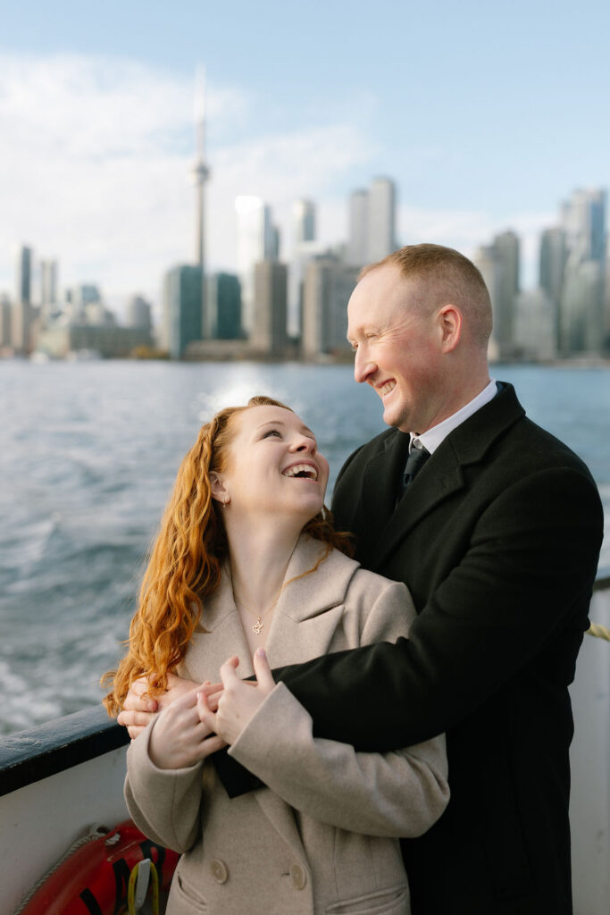 Toronto Island proposal couple on boat with skyline behind laughing