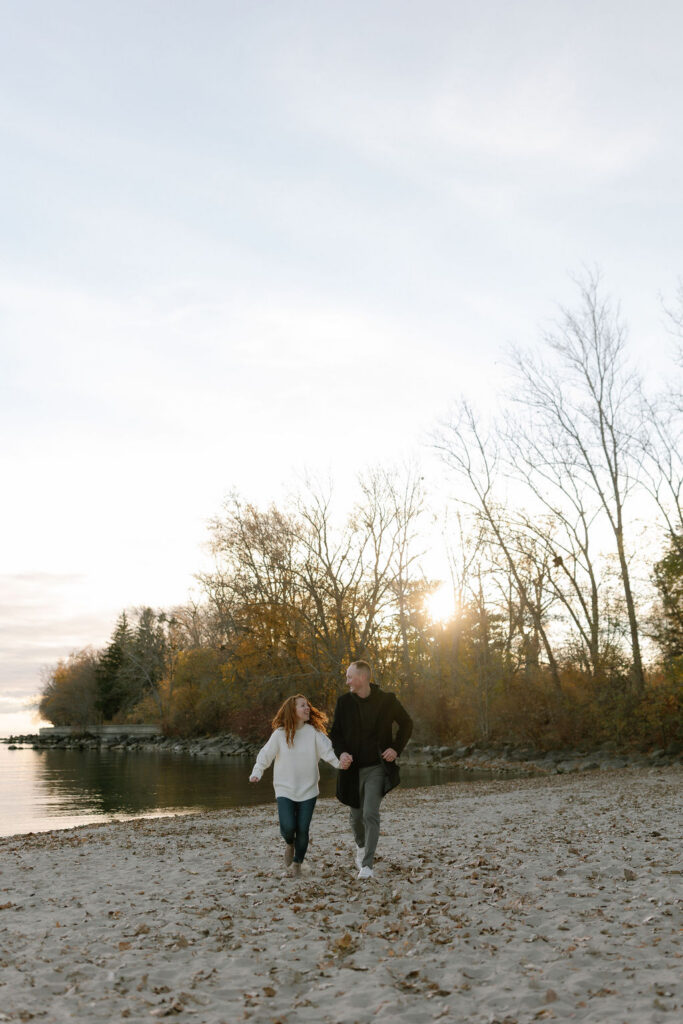 Toronto Island proposal couple running on the beach laughing