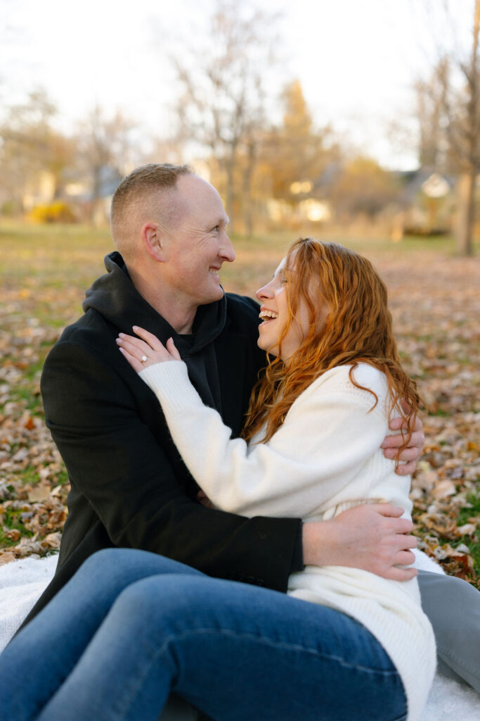 Toronto Island proposal couple sitting laughing with each other