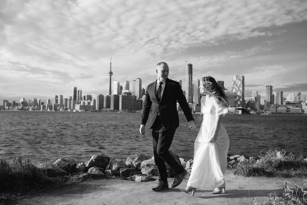 Toronto Island proposal couple walking with skyline behind them