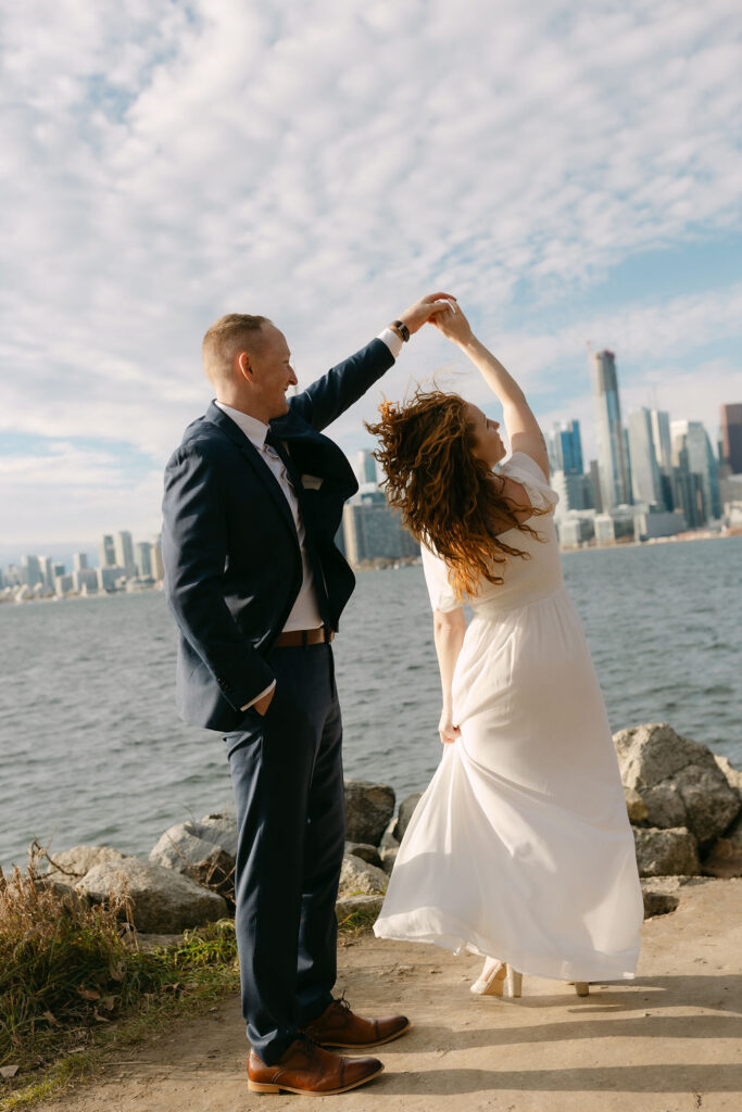Toronto Island proposal couple twirling with skyline behind them