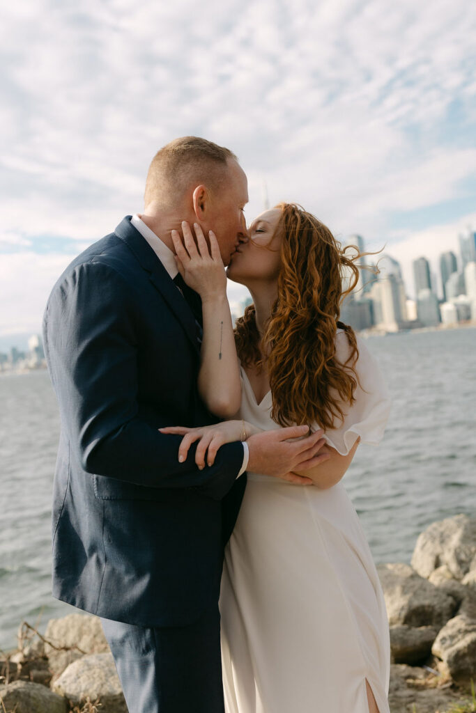 Toronto Island proposal couple kissing with skyline behind them