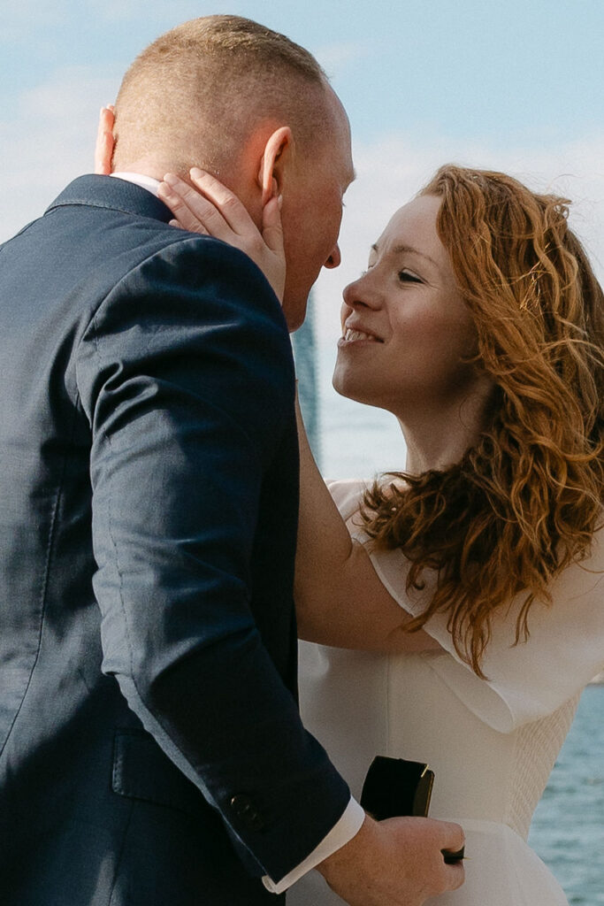 Toronto Island proposal couple looking at each other close up with skyline behind them