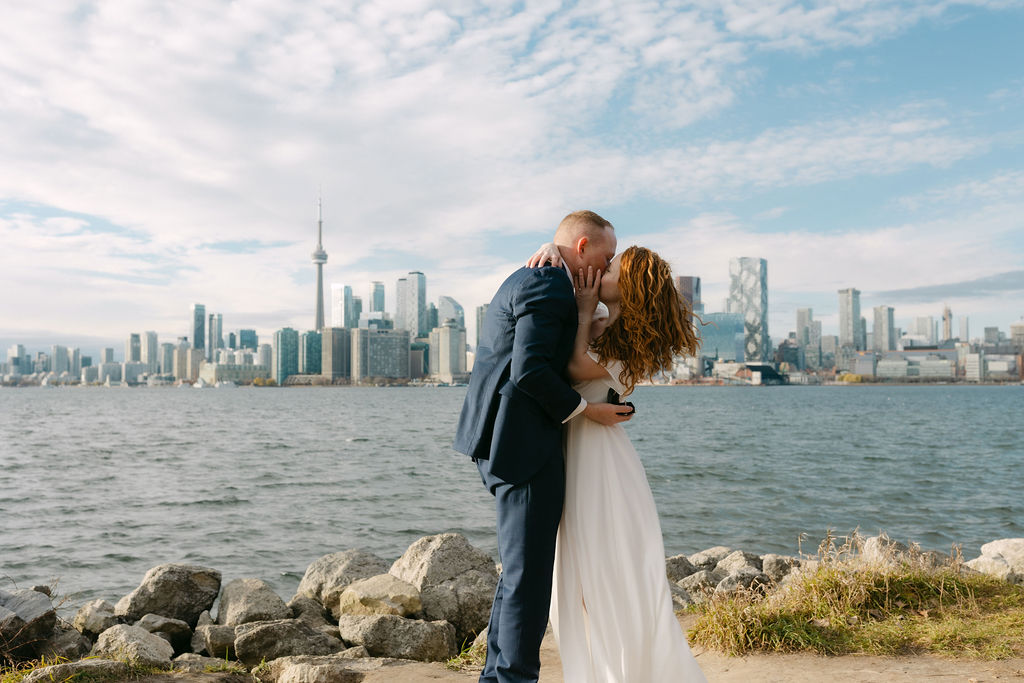 Toronto Island proposal couple kissing with skyline behind them