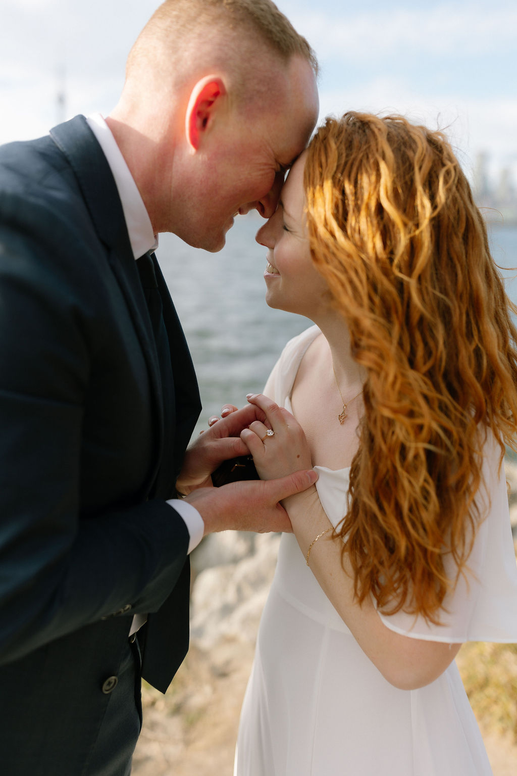 Toronto Island proposal couple smiling closely with skyline behind them