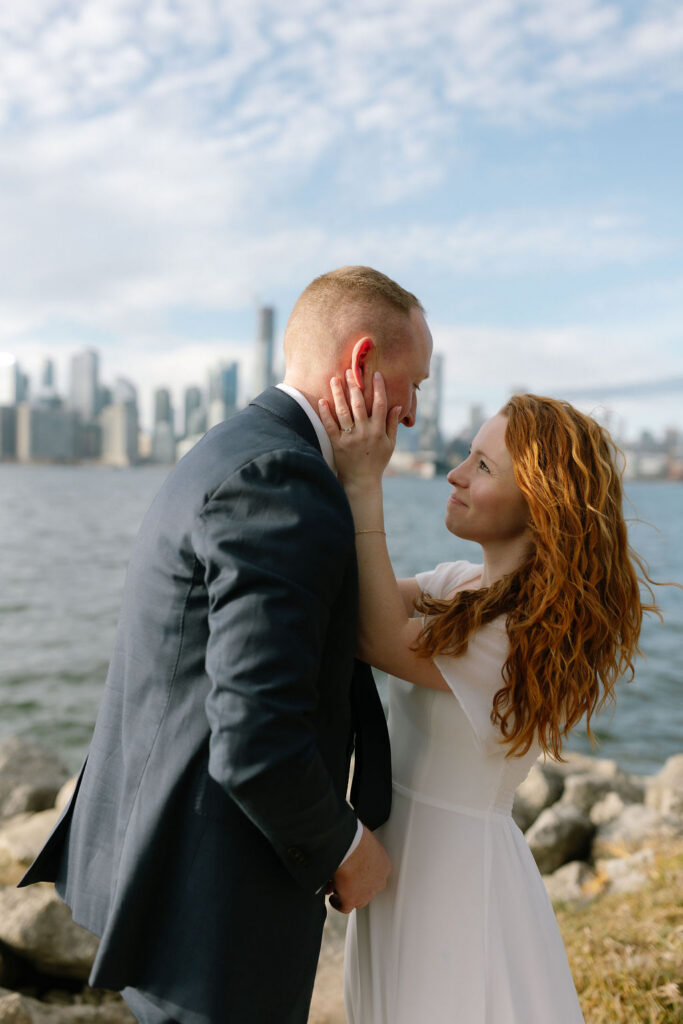Toronto Island proposal couple looking at each other with skyline behind them