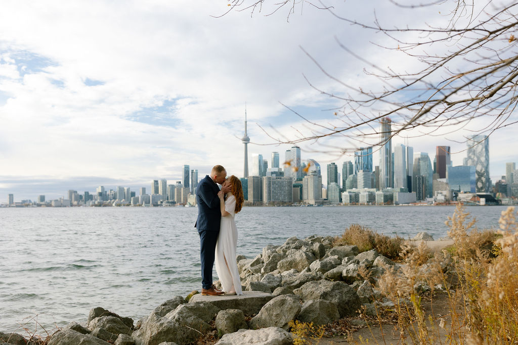 Toronto Island proposal couple kissing with skyline behind them